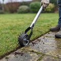 Manual rolling lawn edger cutting a crisp lawn edge