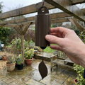 Metal wind bell chime hanging from a pergola