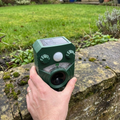 Ultrasonic cat and dog deterrent placed on a low garden wall